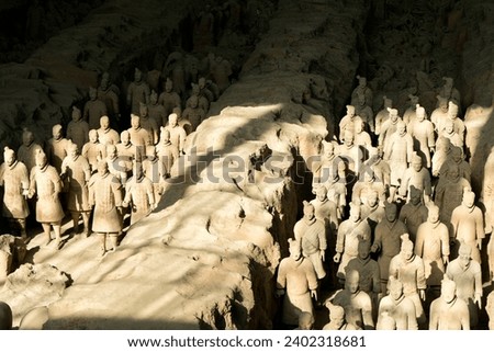 General image of the terracotta warriors in xian. Light entering through the windows creating a play of light and shadows on the warriors