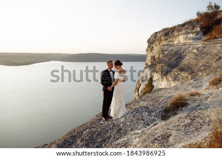 General plan for the lake and the sunset, in the background is a couple in love and kissing.