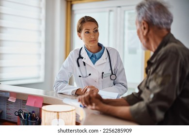 General practitioner communicating with mature patient who is checking in for medical appointment at doctor's office. - Powered by Shutterstock