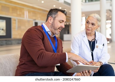 General practitioner discussing patient case status with his medical staff using digital tablet. Pharmaceutical representative showing medical report on digital tablet to mature doctor.