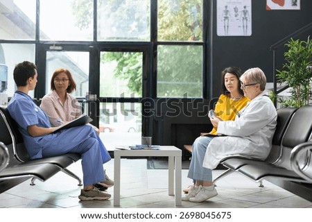 General practitioner preparing glucose test strip for sugar level monitoring in waiting room facility. Asian patient receives guidance on hyperglycemia warning signs and glucose control methods.