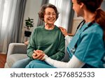 General practitioner talking to a senior woman during home visit.An elderly woman smiles and receives emotional support and help.