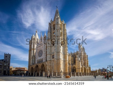 General view of the Gothic Cathedral of León in Castilla y León, Spain, from the square with unrecognizable people walking by