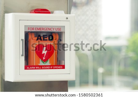 General view of a life saving defibrillator. Portable automated external defibrillator (AED) mounted on the wall in public restroom at airport.