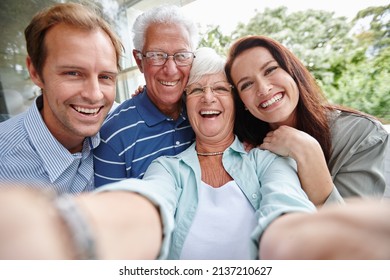 The generation of selfies. Cropped shot of four adults taking a family selfie. - Powered by Shutterstock