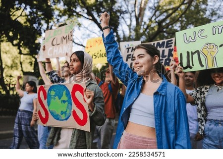 Generation z standing up against climate change. Group of multicultural youth activists carrying posters while marching against global warming. Diverse young people joining the global climate strike.