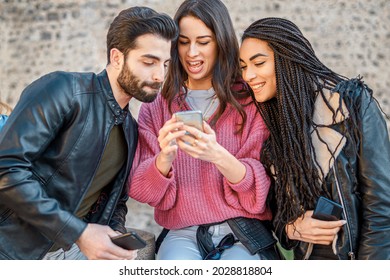 Generation Z Young People Browsing Social Media Content Online With A Smartphone. Zoomers Using Phone Technology Together Outdoor.