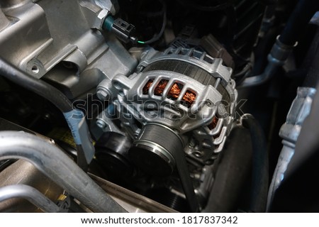 Generator (alternator) installed in the engine of a modern car.