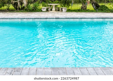Generic blue saltwater pool in tropical setting with closeup of water and nobody in garden as copy space background - Shutterstock ID 2263724987