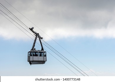 Generic cable car going up or down against a blue cloudy sky.