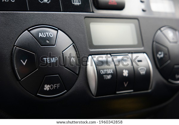 Generic car automatic climate control black plastic\
dials close up shot.