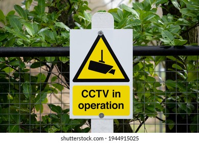 Generic CCTV Warning Sign seen attached to a garden fence at a rural location. The sign helps deter would-be criminals they are being recorded.