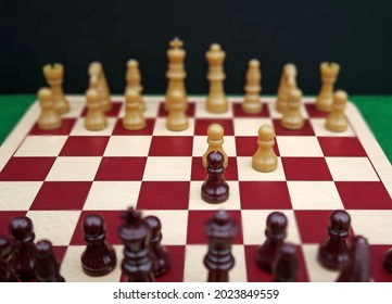 Generic Chess Pieces With Pawns Set Up On Wooden Board To Show The Initial Moves Of A Classic Game Opening Called The Queens Gambit. Metaphor For Intelligence Strategy, Planning And Tactics