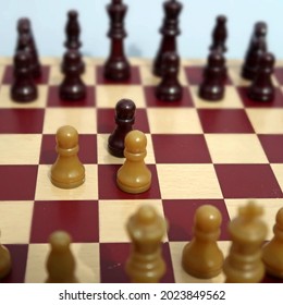 Generic Chess Pieces With Pawns Set Up On Wooden Board To Show The Initial Moves Of A Classic Game Opening Called The Queens Gambit. Metaphor For Intelligence Strategy, Planning And Tactics