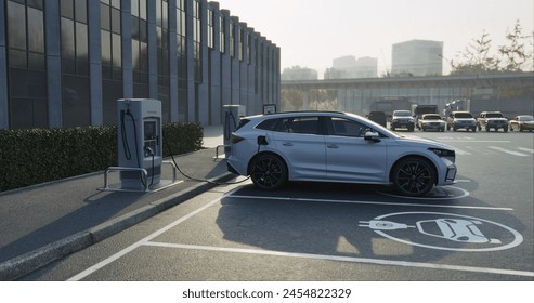 Generic electric car charging at station dock point in parking lot near shopping or office building. City street power hub providing eco-friendly sustainable supply for EV vehicle - Powered by Shutterstock