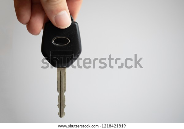 Generic electronic car key in a hand on a\
white background