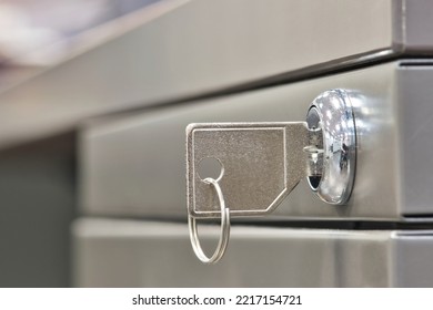 Generic key inserted in a filing cabinet lock. Side view closeup with copy space and selective focus. - Shutterstock ID 2217154721