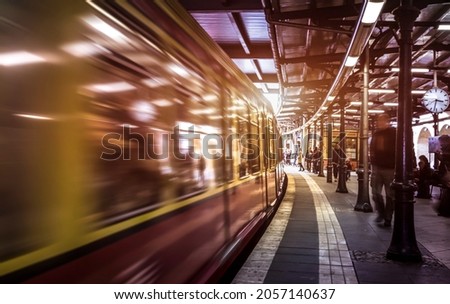 Generic metropolitan platform in Berlin - Urban transportation concept with blurred vehicle moving at underground subway station with unrecognizable people - Soft focus on warm sunset vivid filter 