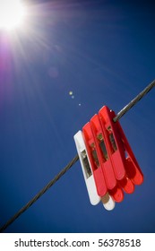 Generic pegs on a washing line in clear blue sky