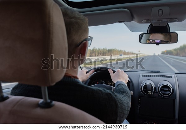Generic photo of man driving a car through slight\
turn. man driving