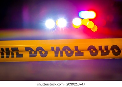 Generic Police Lights And Yellow Crime Scene Tape At Night With Vehicle Headlights Selective Focus