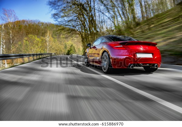 一般的な赤いスポーツカーが外出して速く走る の写真素材 今すぐ編集