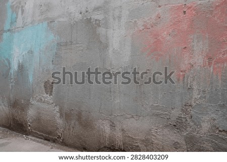 Generic rough city wall with gray cement repairs, muted cyan and coral aerosol overspray, scraped patches, drips and coarse aggregate without writing.