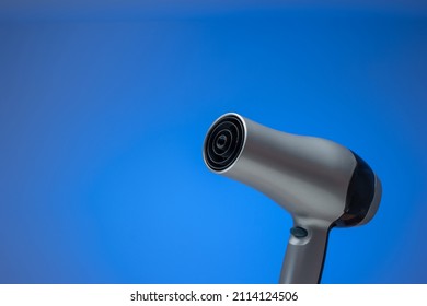 Generic Silver Hair Dryer. Close Up Studio Shot, Isolated On Blue Background.