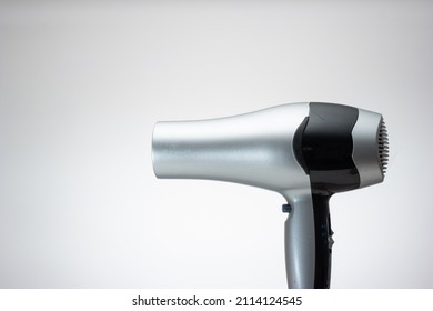 Generic Silver Hair Dryer. Close Up Studio Shot, Isolated On Blue Background.