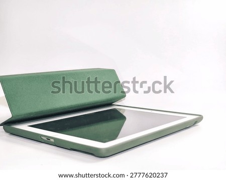 A generic tablet computer with a green protective folio case on a isolated white background, angled for workspace presentation.