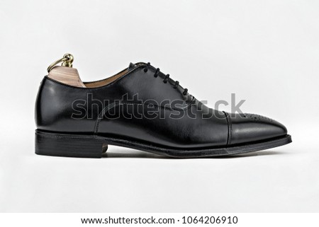 Generic unbranded high quality black brogue shoe shot from the side against a white background.