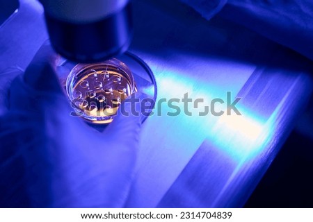 Genetic laboratory worker doing intra cytoplasmic sperm injection