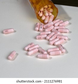 Genetic Lithium Carbonate 300 Mg Capsules Poured From A Prescription Medication Bottle Onto A White Surface.