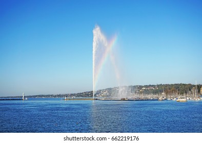 Geneva fountain, Jet deau, and rainbow with building landscape, blue sky and blue sea on evening sunny day in Switzerland