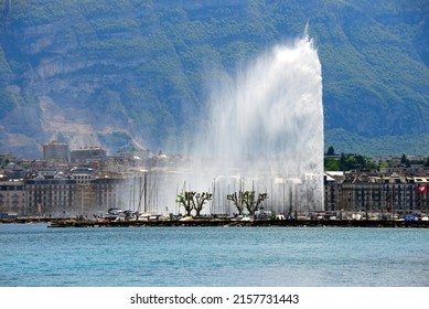 Geneva, Switzerland, Europe - 05.12.2022 : Jet d'Eau fountain (powered by jet engine) on Lake Geneva, city center, Saleve mountain (in France) in background