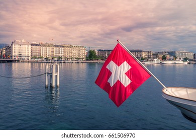 GENEVA, SWITZERLAND- MAY 13:  Swiss flag is on the City's background on May 13, 2017 in Geneva, Switzerland. The second most populous city in Switzerlandand and the most populous city of Romandy.