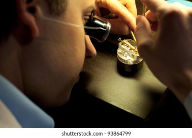 Geneva, Switzerland - November 13, 2011: A Swiss Watchmaker Concentrating On Assembling Fine Internal Watch Parts During The Watches Day, An Annual Exhibition Of Swiss Watchmakers