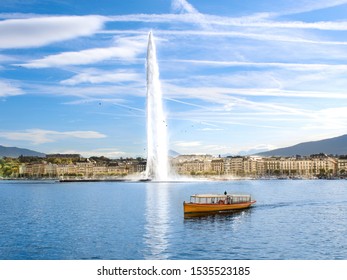 The Geneva Water Fountain, Jet d'Eau, in the city of Geneva, Switzerland. One of the in Geneva so famous yellow shuttle boats. Lake Geneva. Swiss landmark.