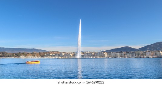 The Geneva Water Fountain, Jet d'Eau, in the city of Geneva, Switzerland. One of the in Geneva famous yellow boats called Mouettes. Switzerland landmark.