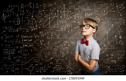 Genius boy in red glasses near blackboard with formulas - Shutterstock ID 178591949