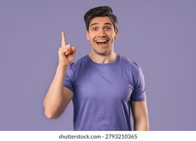 Genius man having idea eureka moment, pointing finger up on violet background. Clever student guy showing answer gesture or remembered what he forgot, memory concept. High quality