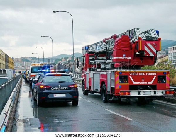 GENOA - ITALY - AUGUST 14, 2018: the column of\
emergency vehicles arriving at the site of the Morandi bridge\
tragedy. In the picture, truck scale of firefighters, ambulances\
and carabinieri vehicle.