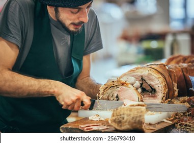 GENOA, ITALY - FEBRUARY 15, 2015: Unidentified Butcher Slicing Italian Pork Roast Porchetta At Food Market In Genoa, Italy