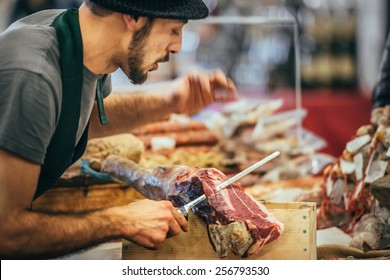 GENOA, ITALY - FEBRUARY 15, 2015: Unidentified Butcher Slicing Italian Dry-cured Ham Prosciutto At Food Market In Genoa, Italy