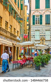 Genoa, Italy - July 06, 2019: Old Street In Genoa And People In Cafe