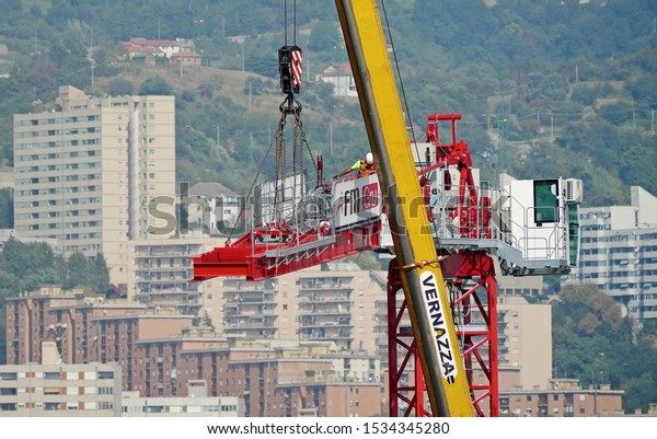 GENOA, ITALY - SEPTEMBER 30, 2019: assembly of a\
construction crane of the company FM Gru on the west site of the\
new Polcevera viaduct. Technicians and logistic support of the\
Vernazza company.