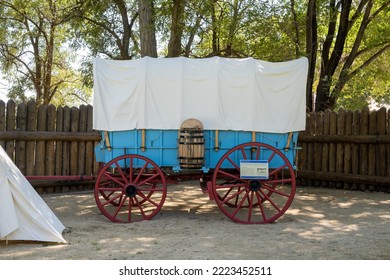 Genoa, NV, USA. 2022-09-17. Overnight Canvas Tent Beside A Blue Prairie Schooner Wagon With Red Wheels At The Mormon Station Historic Park. 