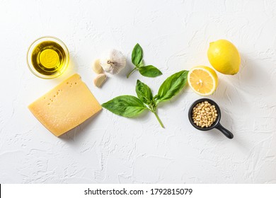 Genovese pesto ingredients concept or ingredients Parmesan cheese, basil leaves, pine nuts, olive oil, garlic, salt, pepper and mortar for cooking on white old stone table top view with copy space - Powered by Shutterstock