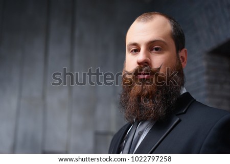 Gentelman fashion and style. Handsome young bearded man at suit and tie.