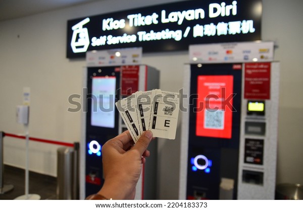 Genting Highland, Malaysia : 11 September 2022\
- hand holding cable car ticket with self service ticketing machine\
as background